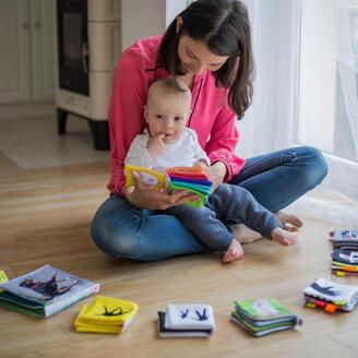 Une femme montre un livre à un bébé.