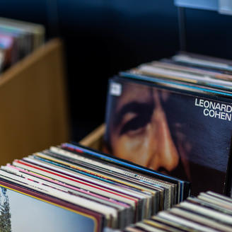Pochettes de disque vinyles 33 tours dans un bac. Un disque de Leonard Cohen bien visible.