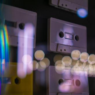 Cassettes audio dans une vitrine avec reflets de lumière.