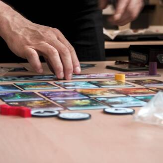 Main qui manipule les pièces d'un jeu de société.