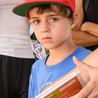 Jeune garçon entouré de livres.