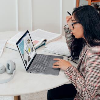 Jeune femme qui travaille de chez elle derrière son ordinateur