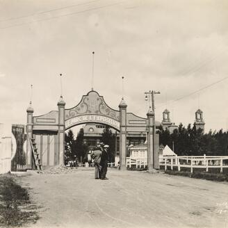 Deux hommes se tiennent devant l'entrée principal du parc de l'exposition de 1926