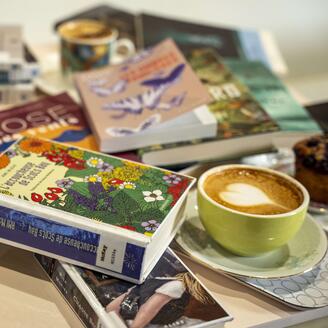 Pile de livres pêle-mêle avec des cafés au motif de coeur