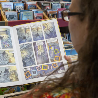 Sur une page du livre Le petit astronaute, de Jean-Paul Eid, deux enfants lisent ensemble un livre de Tintin.