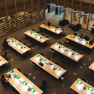 Tables d'une salle de lecture aux murs boisés.