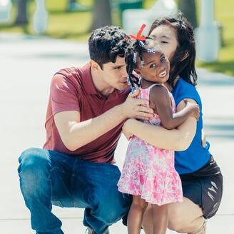 Famille mixte : père caucasien, mère asiatique, fillette afrodescendante.