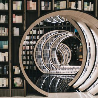 Sculpture circulaire devant des étagères contenant des livres.