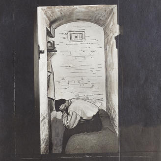 Un homme pose la tête sur ses genoux, assis sur un lit dans une cellule de prison. 