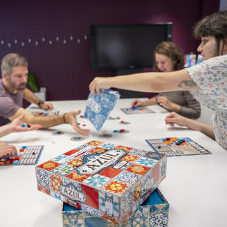 4 personnes autour d'une table jouant à un jeu de société