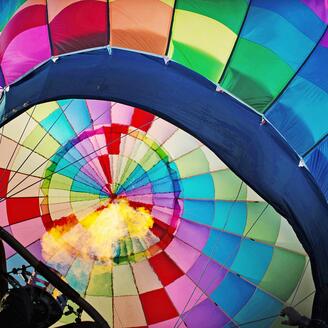 Montgolfière en vol, aux couleurs de l'arc-en-ciel de la fierté