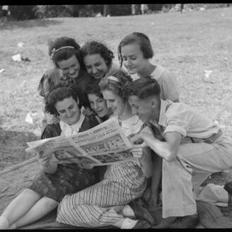 Groupe de jeunes des années 1930 rassemblé pour lire un journal