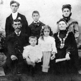 Photo ancienne d'une famille montrant le père, la mère et leurs cinq enfants.