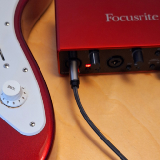 Guitare électrique branchée à un appareil Focusrite