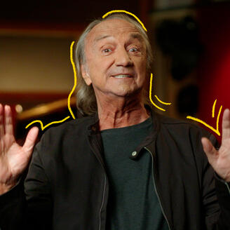 Le chanteur Claude Dubois levant les mains dans un studio de musique
