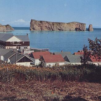 Paysage mettant de l'avant la ville de Percé et le rocher percé, à l'horizon.