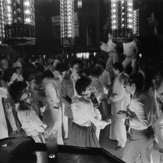 Hommes et femmes sur la piste de danse d'une discothèque.
