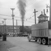 L’arrivée du train bloque le passage d’un camion au croisement des rues Saint-Augustin et Saint-Ambroise à Montréal, 29 août 1945.