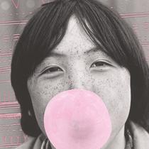 Photo noir et blanc d'un enfant inuit qui fait une bulle rose avec sa gomme à mâcher