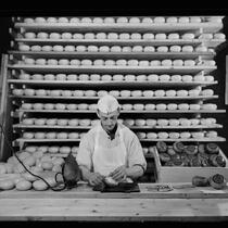 Homme emballant un fromage.