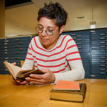 Une bibliothécaire consulte un livre ancien en langue autochtone