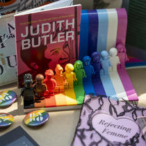 Quelques zines dont « Judith Butler » et » Rejecting Femme », macarons de BAnQ aux couleurs de l'arc-en-ciel et personnages Lego de différentes couleurs.