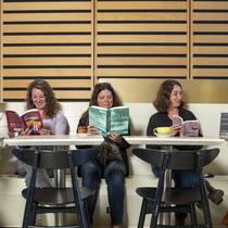 Cinq femmes lisent des livres côte-à-côte.
