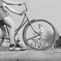 Photo ancienne présentant deux jeunes femmes à vélo.