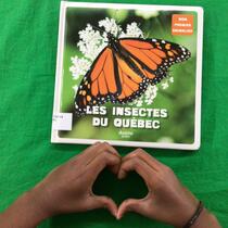 Deux mains d'enfant tiennent le livre "Les insectes du Québec" au-dessus d'un rideau vert.