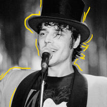 Photo d'archives en noir et blanc de Jean Leloup, jeune, chantant avec un chapeau haut de forme noir
